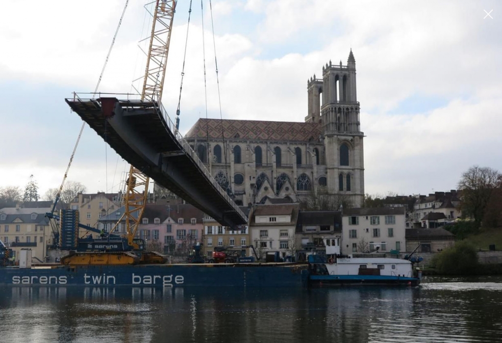 Mantes-la-Jolie, ce lundi. L’ouvrage est arrivé sur la Seine en barge. A bord, une grue a d’abord soulevé la structure avant d’opérer une rotation à 360 degrés, posant finalement cette première partie à côté du pont de Limay. (Photo LP/Virginie Wéber)