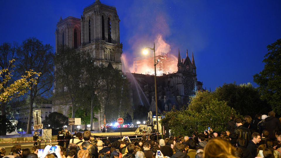 Des badauds sont massés sur les quais alors que Notre-Dame brûle, à Paris le 15 avril 2019 (Photo ERIC FEFERBERG - AFP)